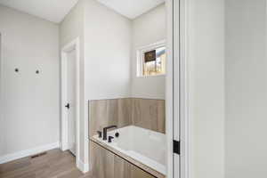Full bathroom with a bath and wood finish floors