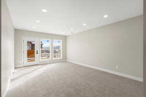Carpeted spare room featuring baseboards and recessed lighting