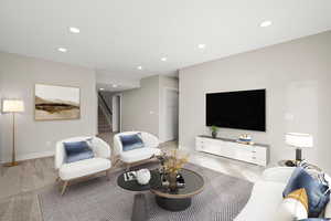 Living area with recessed lighting, light colored carpet, and stairs