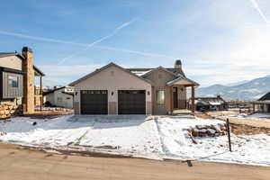 View of front of property featuring board and batten siding, a chimney, a mountain view, and an attached garage