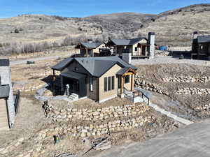 View of front of house with a mountain view, a balcony, and a shingled roof