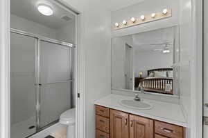 Ensuite bathroom featuring vanity, a shower stall, and light tile patterned floors