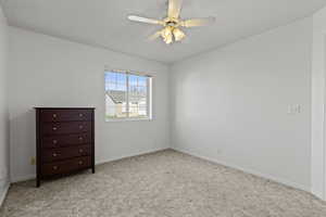 Spare room with light colored carpet and ceiling fan