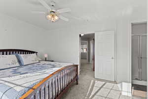 Carpeted bedroom with a ceiling fan