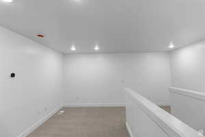 Carpeted empty room featuring baseboards and recessed lighting