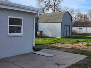 View of patio with a shed