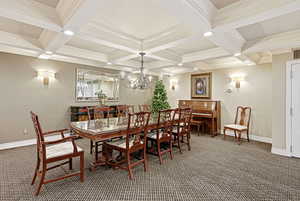 Carpeted dining space with recessed lighting, coffered ceiling, beamed ceiling, crown molding, and a chandelier