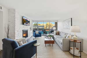 Living room with a fireplace and a wall of windows