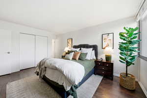 Bedroom featuring dark wood finished floors and a closet