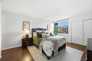 Bedroom featuring dark wood finished floors and baseboards