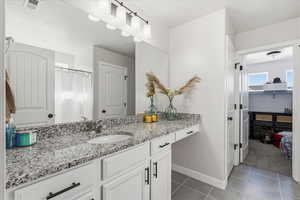 Full bathroom featuring vanity, a shower with curtain, light tile patterned floors, a spacious closet, and light carpet