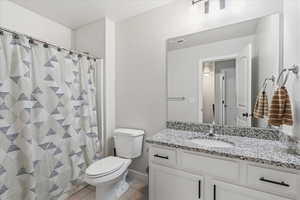 Bathroom with a shower with shower curtain, vanity, and light tile patterned floors