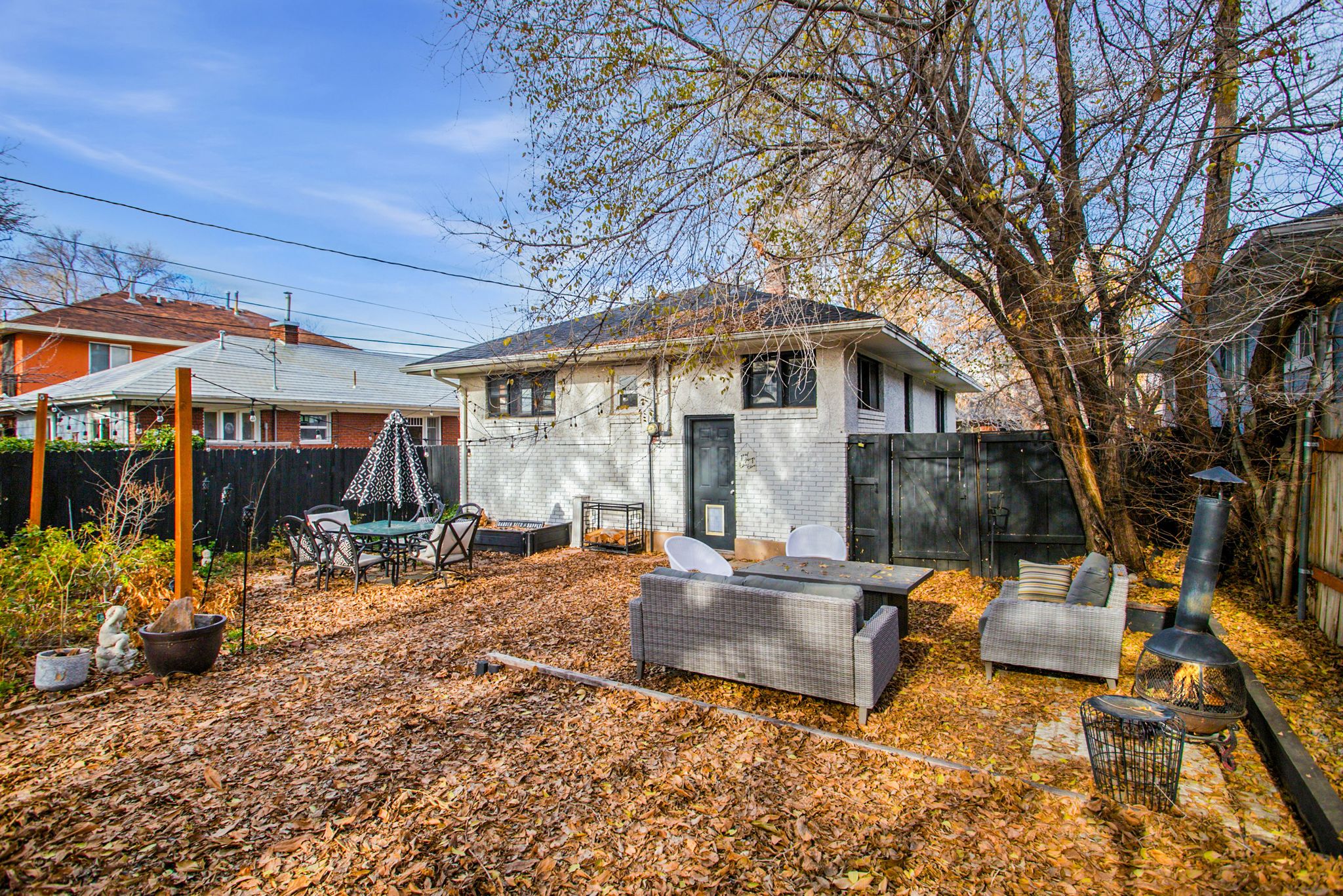 Rear view of property with brick siding, a fenced backyard, and a patio