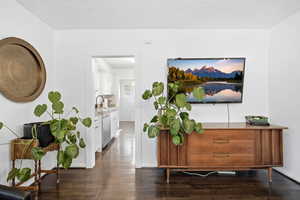 Corridor with a textured ceiling and dark wood finished floors