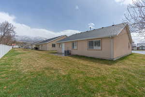Rear view of house with a patio area, a mountain view, and roof with shingles