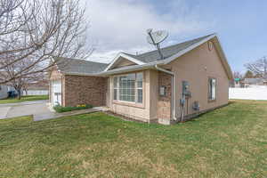 View of home's exterior with a shingled roof, stucco siding, driveway, and a garage