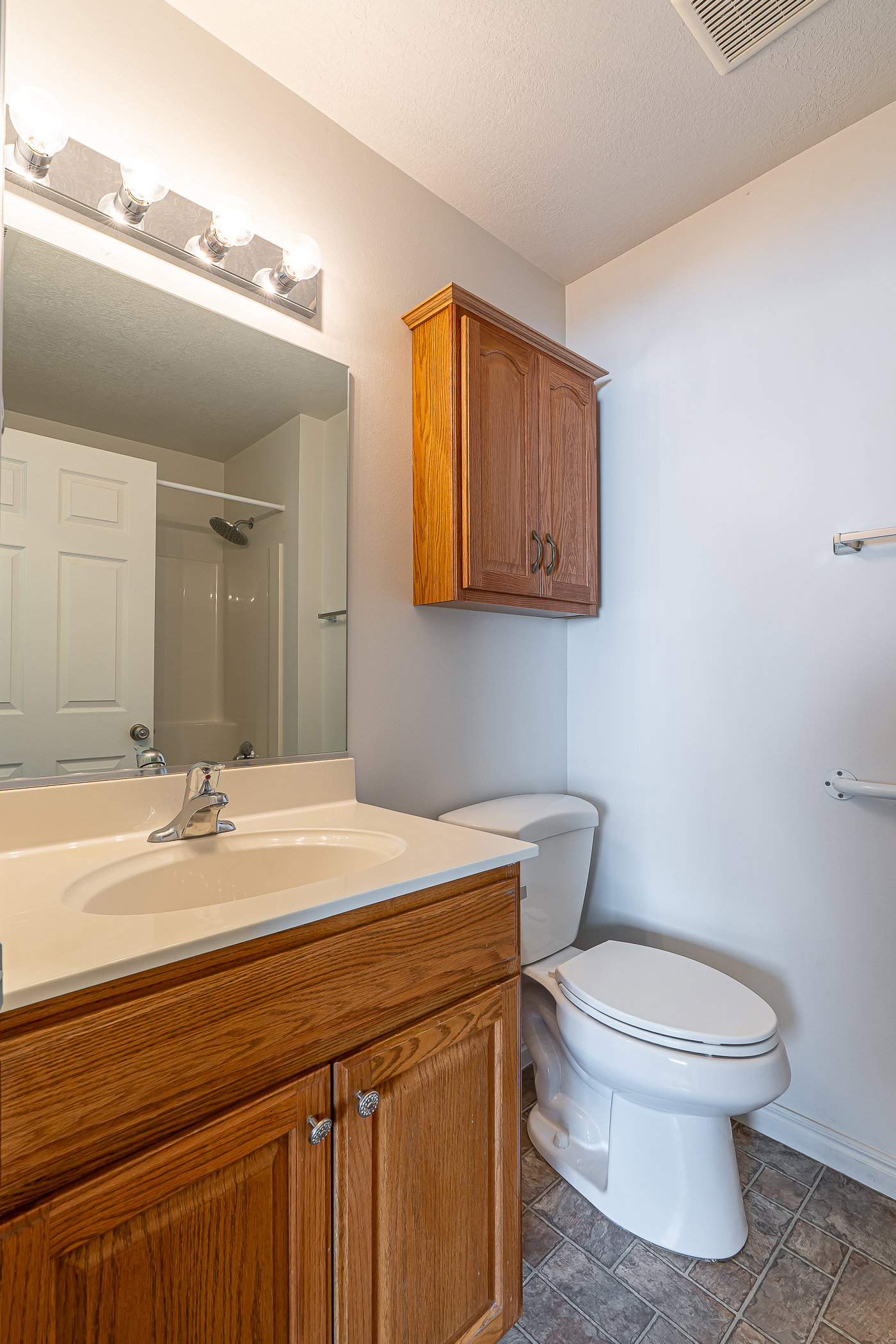 Bathroom featuring a shower, vanity, and a textured ceiling