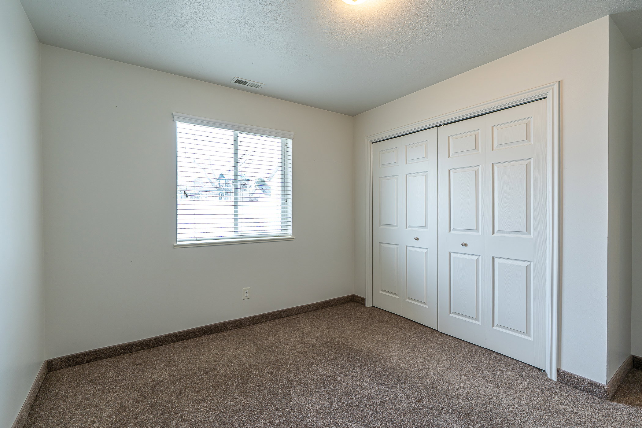 Unfurnished bedroom featuring a textured ceiling, carpet floors, and a closet