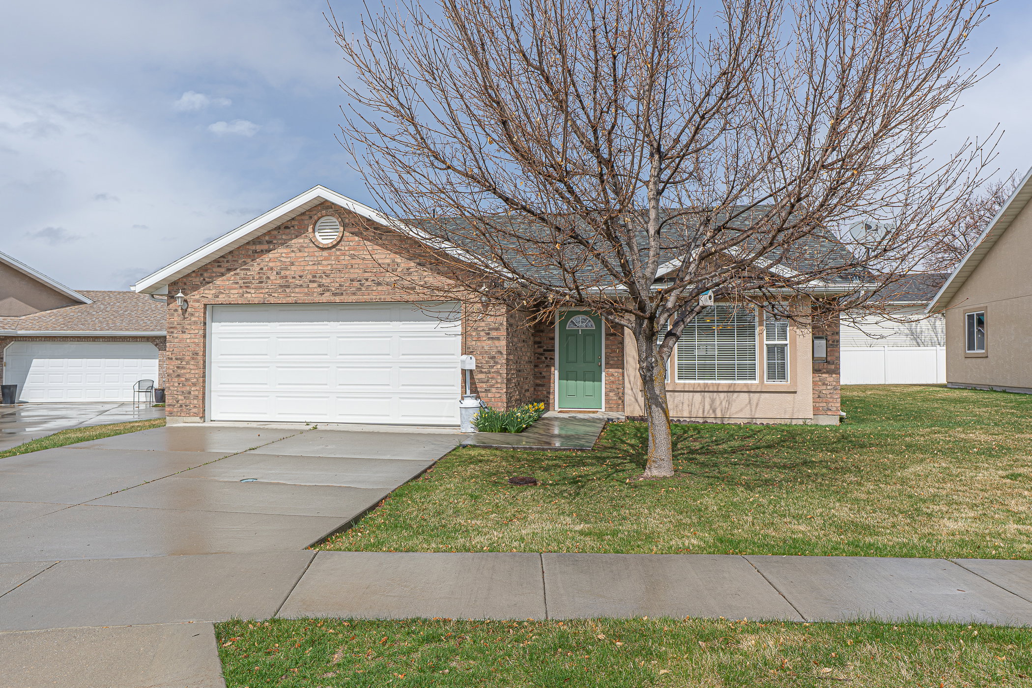 Single story home featuring concrete driveway, brick siding, and an attached garage