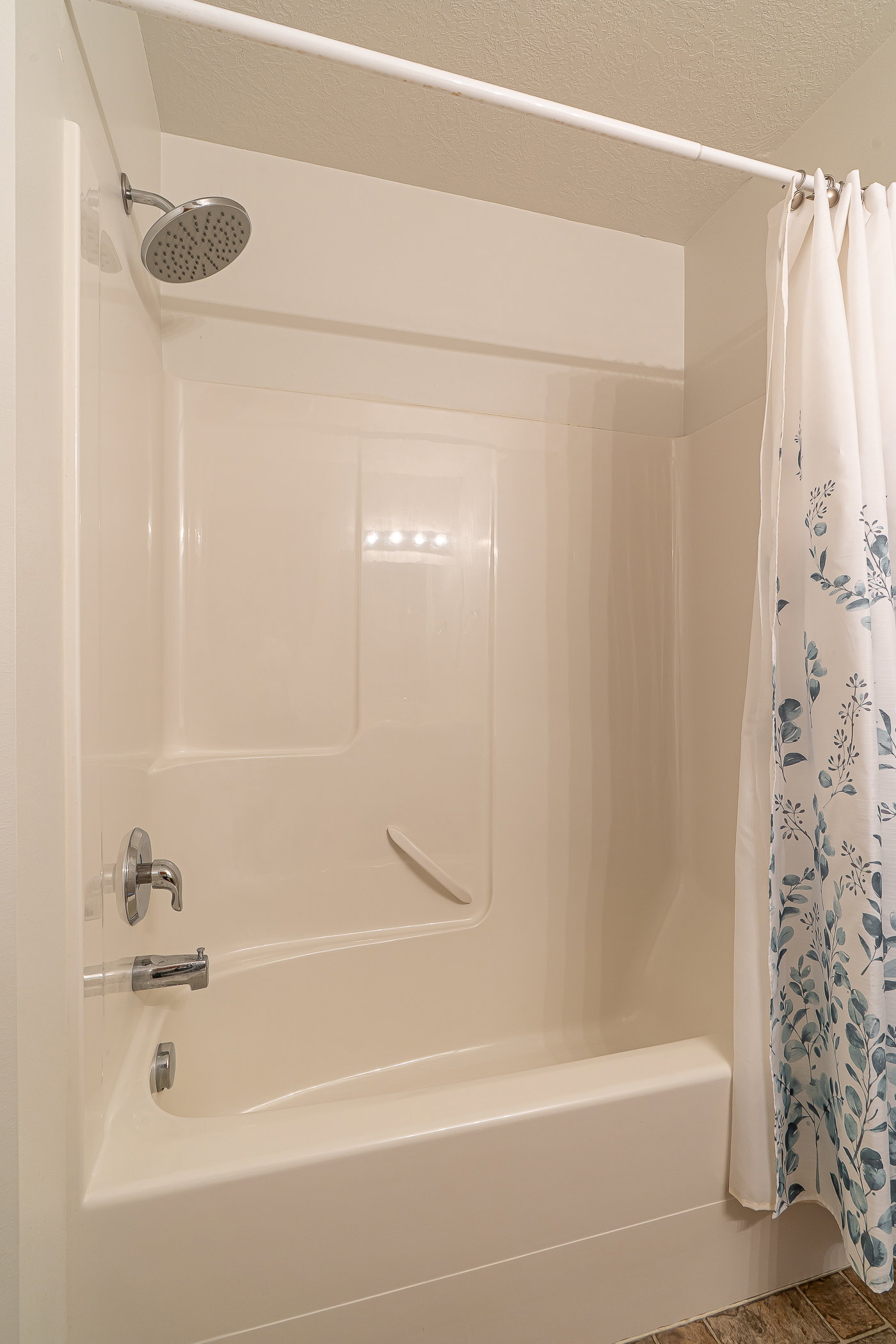 Full bathroom with shower / bath combo with shower curtain and a textured ceiling