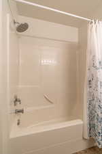 Full bathroom with shower / bath combo with shower curtain and a textured ceiling