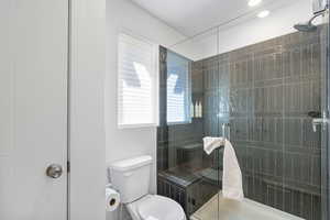 Full bath featuring toilet and a shower stall