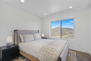 Carpeted bedroom with a mountain view and recessed lighting