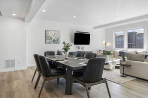 Dining area with light wood-type flooring, recessed lighting, and beamed ceiling