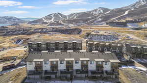 Aerial view of property's location with a mountainous background and apartment complex / building