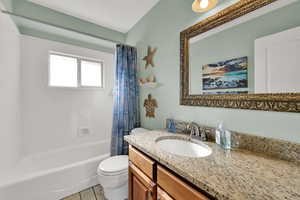 Full bathroom featuring shower / bathtub combination with curtain, vanity, and light tile patterned flooring