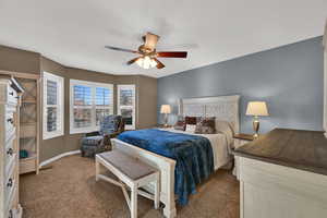 Bedroom with dark carpet and a ceiling fan