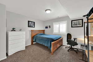Bedroom featuring carpet flooring and a desk