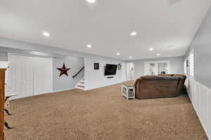 Living room with carpet, recessed lighting, and stairway