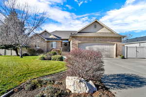 View of front of home with brick siding, driveway, an attached garage, and a shingled roof