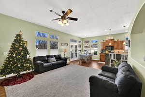 Living area featuring dark wood finished floors, a textured ceiling, ceiling fan, and recessed lighting