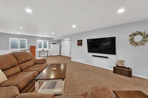 Carpeted living area featuring recessed lighting and baseboards