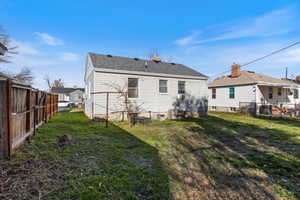 Rear view of house featuring a fenced backyard
