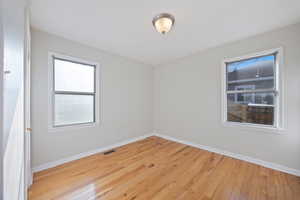 Spare room featuring light wood-style floors and baseboards