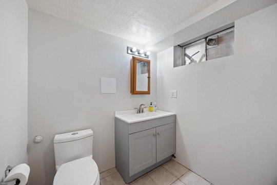 Half bathroom featuring a textured ceiling, vanity, and light tile patterned flooring