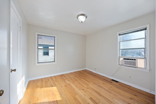 Unfurnished room featuring light wood-style floors, cooling unit, and plenty of natural light