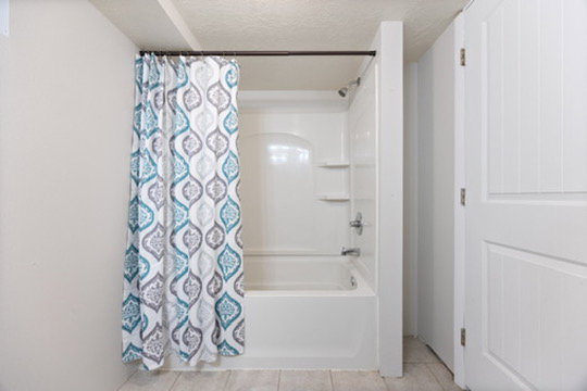 Bathroom with shower / bath combination with curtain, a textured ceiling, and light tile patterned floors