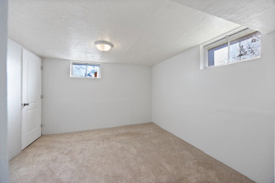 Basement featuring a textured ceiling and carpet floors