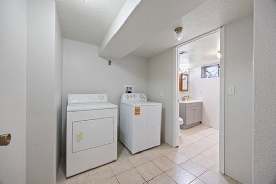 Washroom featuring washing machine and dryer, light tile patterned flooring, and a textured ceiling