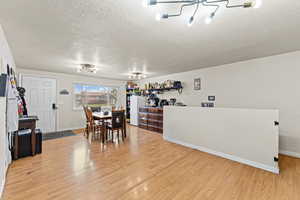 Dining area with a textured ceiling and light wood-type flooring