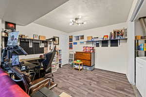 Home office featuring wood finished floors, a textured ceiling, washer / clothes dryer, and a chandelier