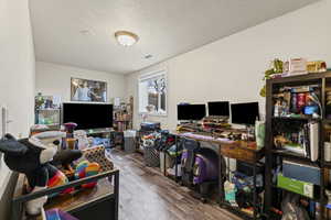 Home office featuring a textured ceiling and wood finished floors