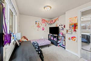 Carpeted bedroom with a textured ceiling
