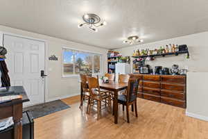 Dining space featuring a textured ceiling and light wood finished floors