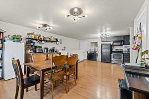 Dining space featuring a textured ceiling and light wood-style floors