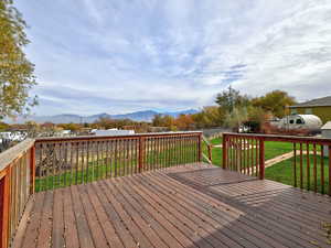 Deck with a mountain view and a lawn
